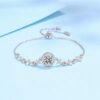 Elegant silver moissanite bracelet with star-shaped accents and center halo stone on a blue background
