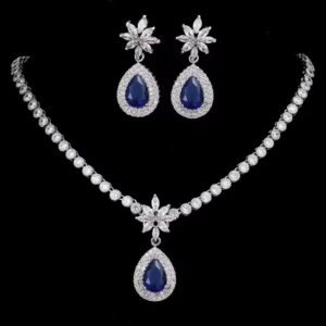 Elegant sapphire and crystal teardrop necklace and earring set with floral accents on black background