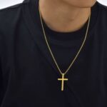 Gold cross necklace on a man with a black shirt